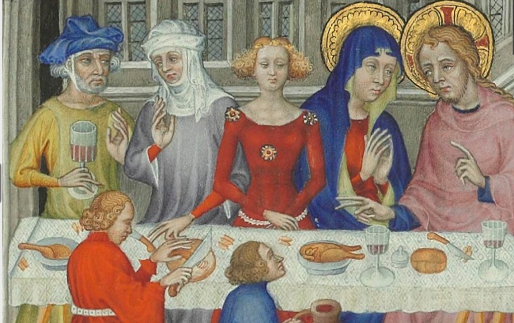 Fem medeltida personer som sitter runt ett bord dukat med en mönstrad vit duk. 