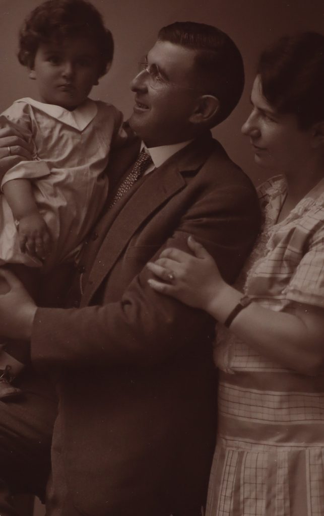 Fotografi av en man och en kvinna där mannen håller ett barn i famnen.