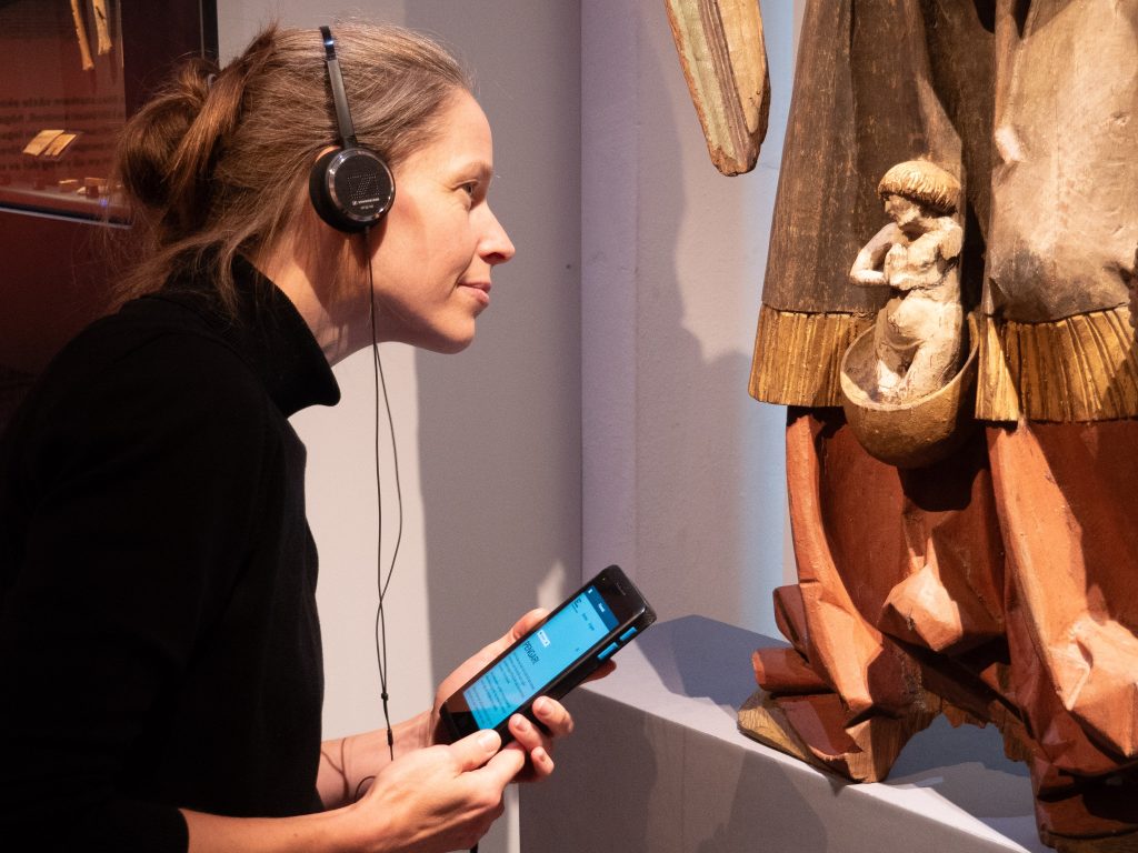 A visitor engaging in the exhibition with the help of "digital companion"-device.