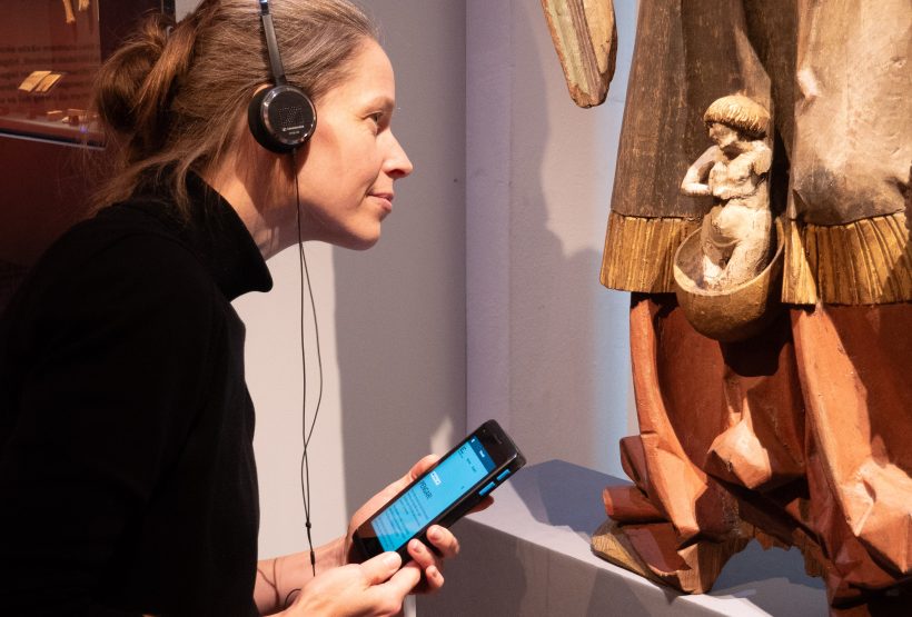 A visitor engaging in the exhibition with the help of "digital companion"-device.