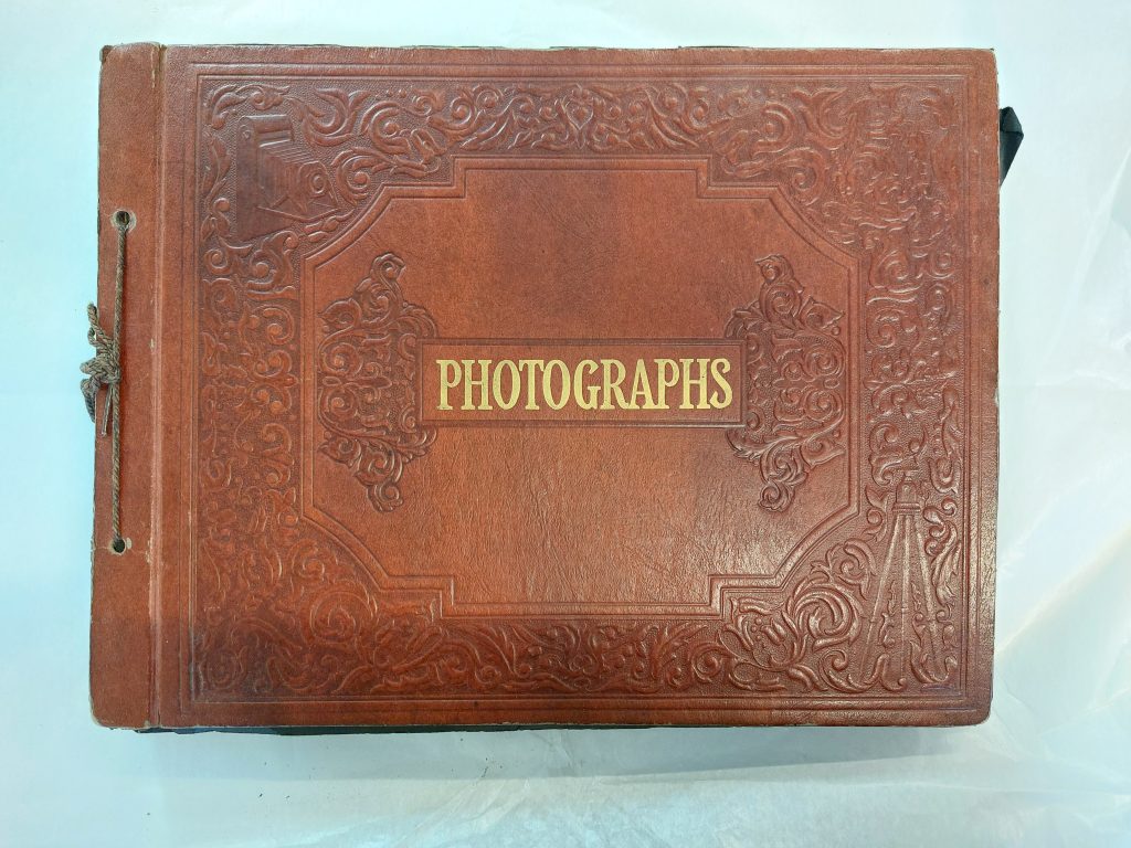 Bild av fotoalbum med läderklädda pärmar och texten "Photographs".