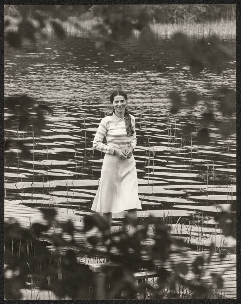 Svartvitt fotografi föreställande Nina Kwiek stående i vattenbryn.