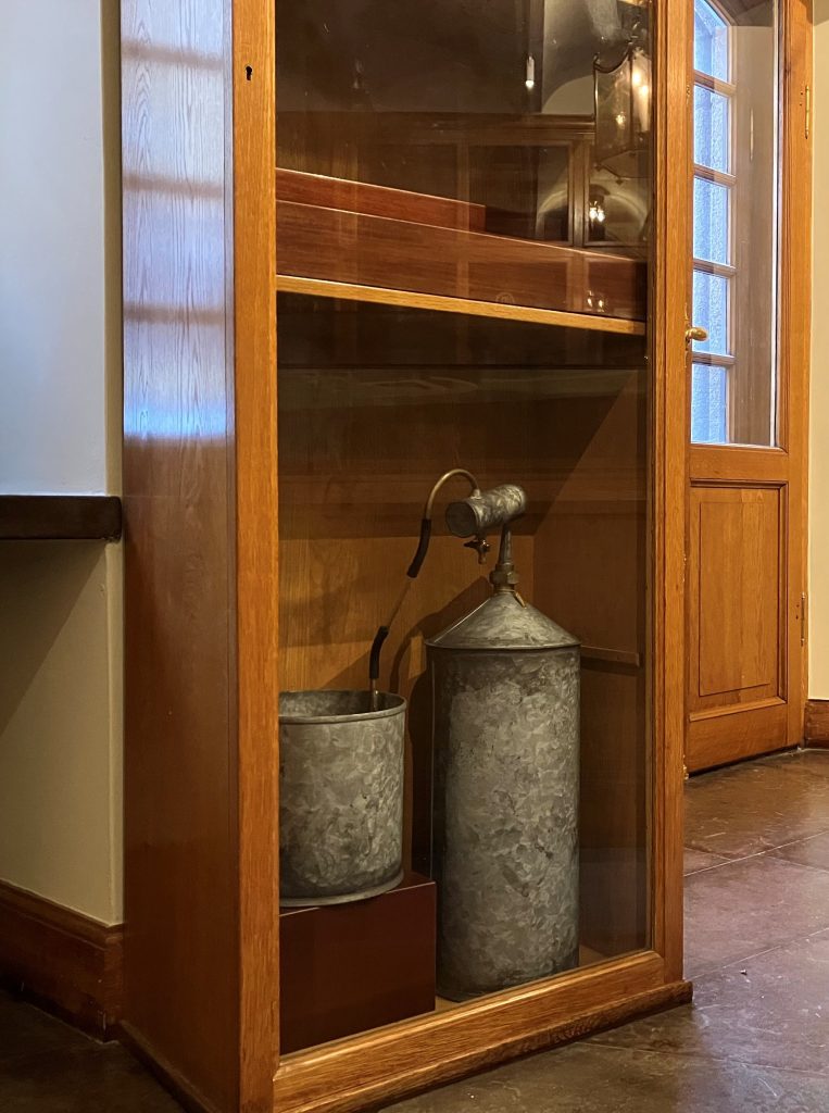 En apparat av grå metall i ett skåp av trä.