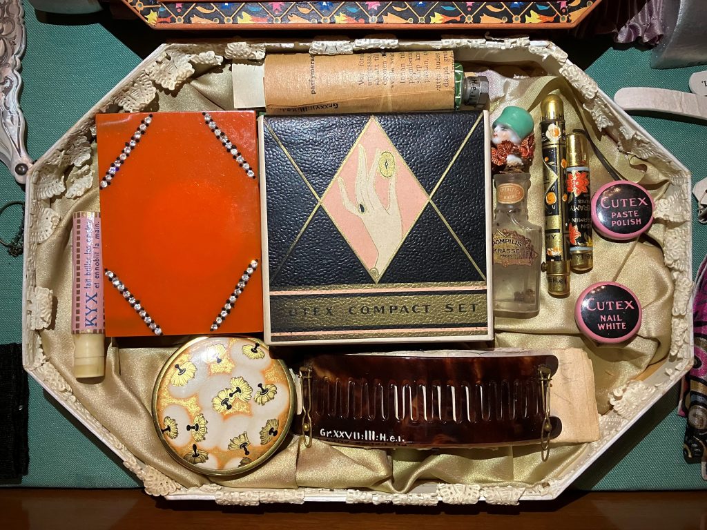 Åttkantig låda med mindre små askar och burkar i olika färger.