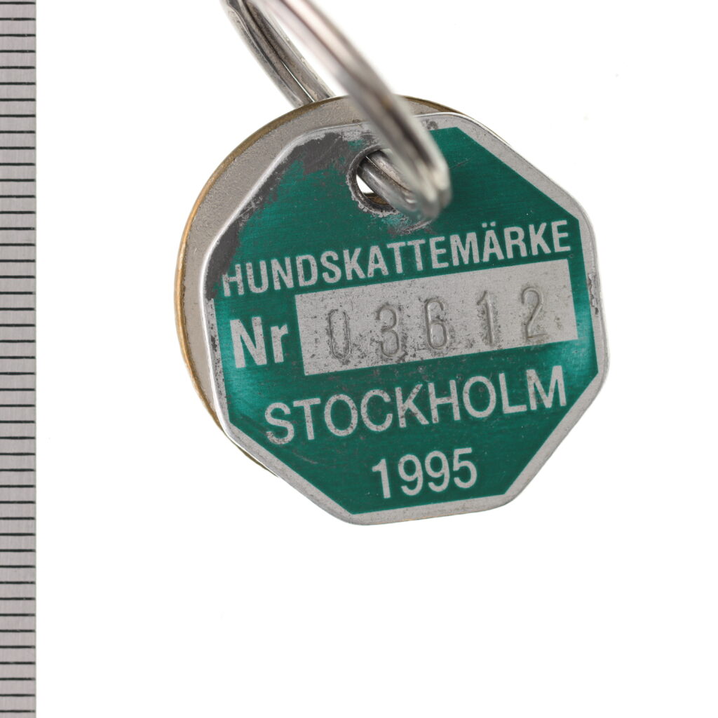 Åttkantigt, grönt metallmärke med siffror.