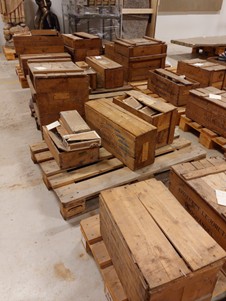 Färgfoto av en massa trälådor som står på lastpallar.