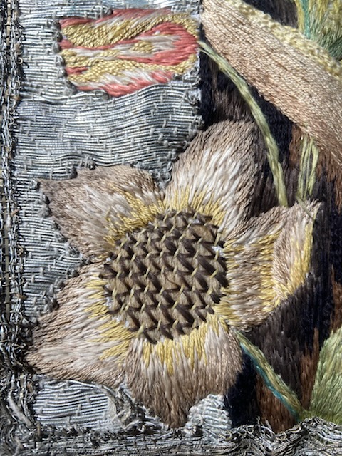 Broderade blommor i olika färger.